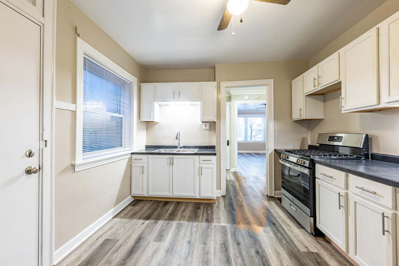 8401 South Paulina Street, Unit 1 Chicago, IL 60620 - Photo 15 of 17 a kitchen with granite countertop white cabinets a sink dishwasher a stove and a refrigerator with wooden floor