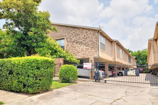 an empty room with a fireplace and a ceiling fan