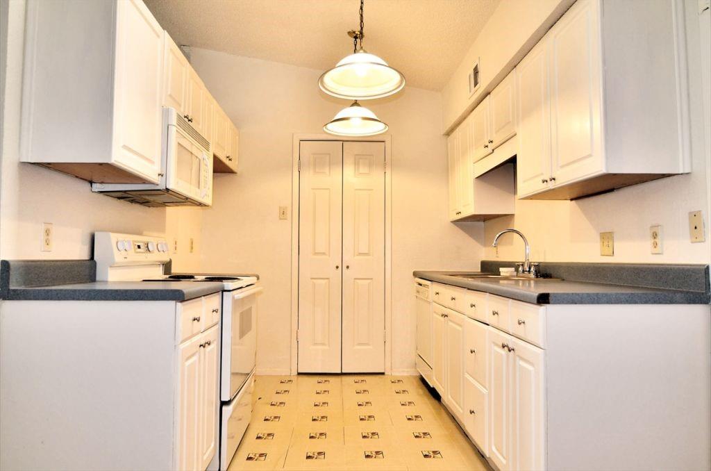 6503 Ridgecrest Road, Unit 110/J Dallas, TX 75231 - Photo 3 of 10 a kitchen with stainless steel appliances granite countertop a sink a stove and a refrigerator