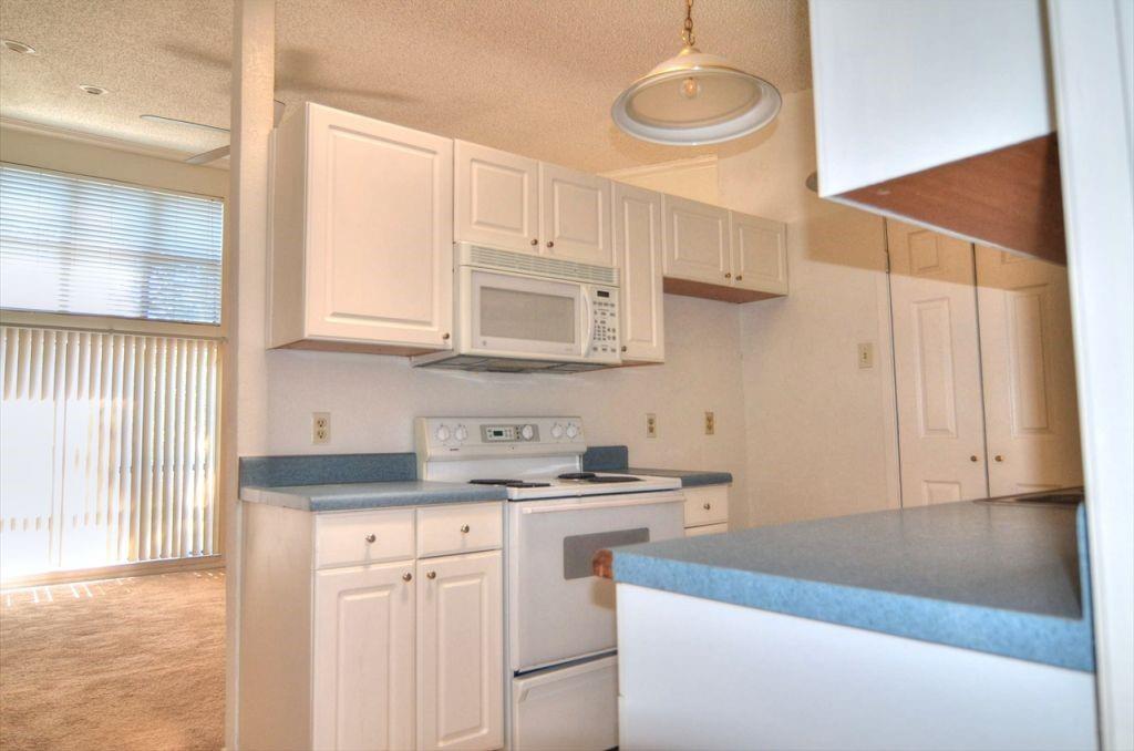6503 Ridgecrest Road, Unit 110/J Dallas, TX 75231 - Photo 4 of 10 a kitchen with stainless steel appliances granite countertop a sink a stove and a microwave