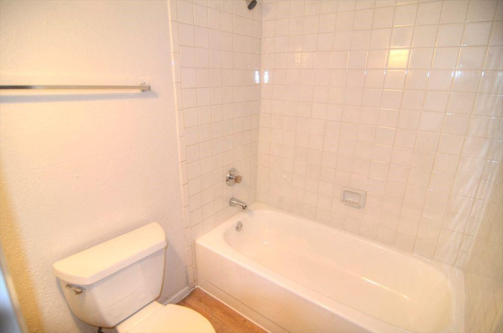 6503 Ridgecrest Road, Unit 110/J Dallas, TX 75231 - Photo 7 of 10 a white toilet sitting next to a bath tub