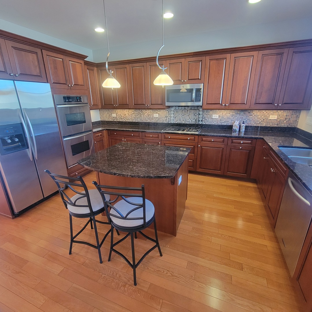 13 Busse Highway Park Ridge, IL 60068 - Photo 9 of 28 a kitchen with stainless steel appliances granite countertop a stove a sink a microwave and a refrigerator