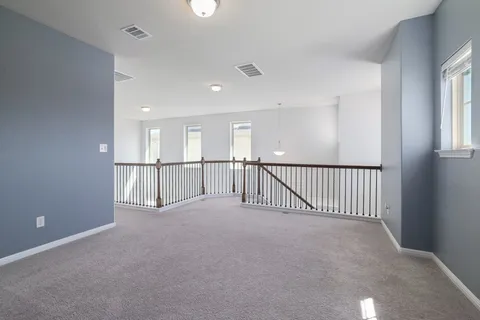 a view of a hallway to a livingroom with furniture