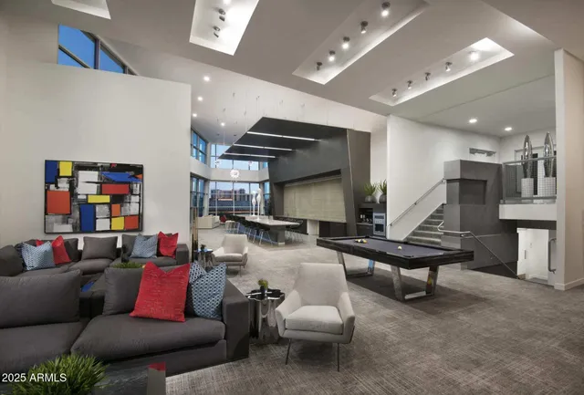 a living room with furniture kitchen view and a wooden floor