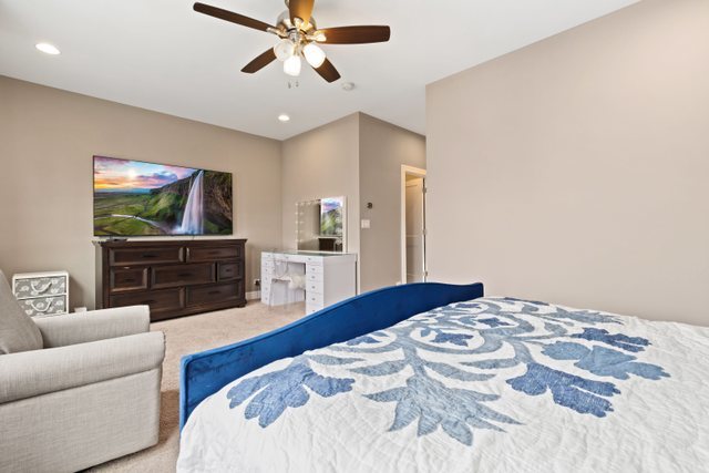 Undisclosed Address Chicago, IL 60634 - Photo 18 of 44 a bedroom with a bed a couch and a flat screen tv