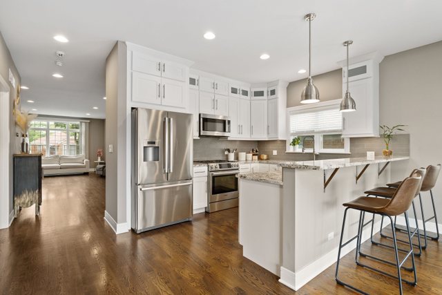 Undisclosed Address Chicago, IL 60634 - Photo 9 of 44 a kitchen with kitchen island white cabinets and stainless steel appliances