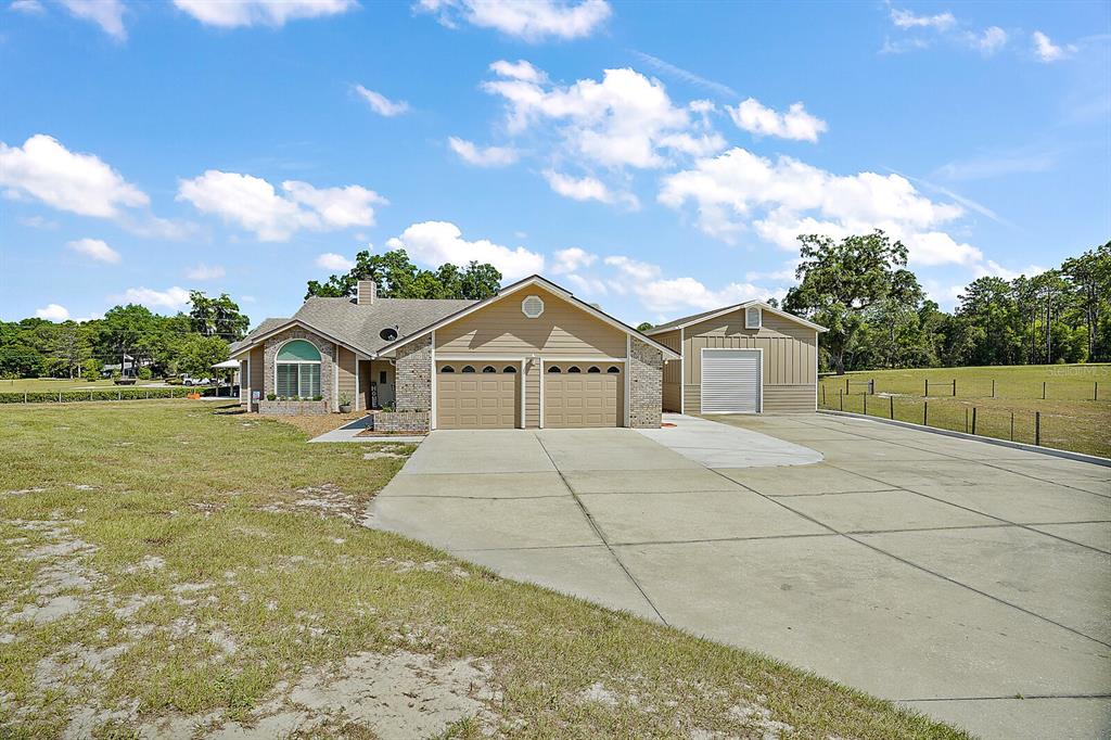 21706 Lake Seneca Road Eustis, FL 32736 - Photo 1 of 1 Front Exterior with Attached 2-Car Garage and Detached RV Storage and Workshop