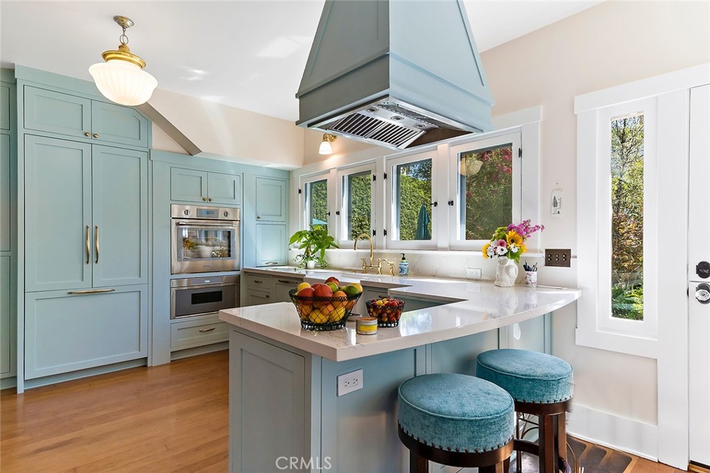 3216 2nd Street Long Beach, CA 90803 - Photo 22 of 62 a kitchen with stainless steel appliances granite countertop a stove a refrigerator a sink a dining table and chairs with wooden floor