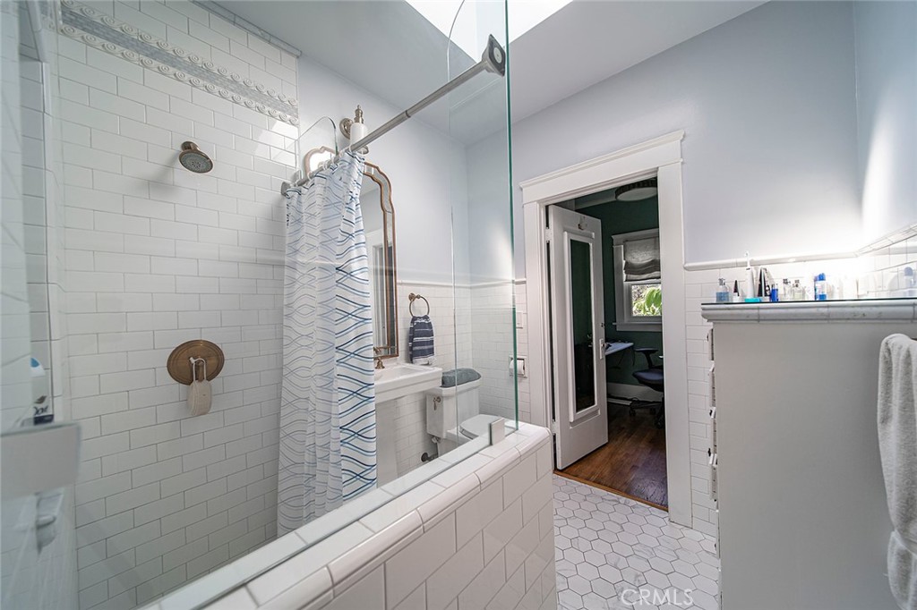 3216 2nd Street Long Beach, CA 90803 - Photo 52 of 62 a bathroom with a granite countertop sink a mirror and shower