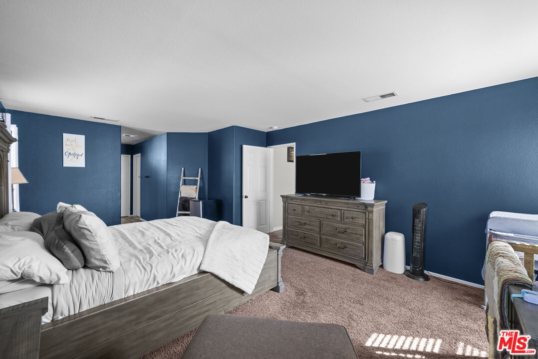 40335 Reata Road Palmdale, CA 93550 - Photo 24 of 37 a bedroom with a bed and flat screen tv