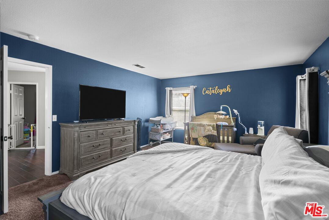 40335 Reata Road Palmdale, CA 93550 - Photo 25 of 37 a bedroom with a bed and a flat screen tv