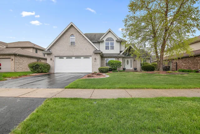 a front view of a house with a yard and garage