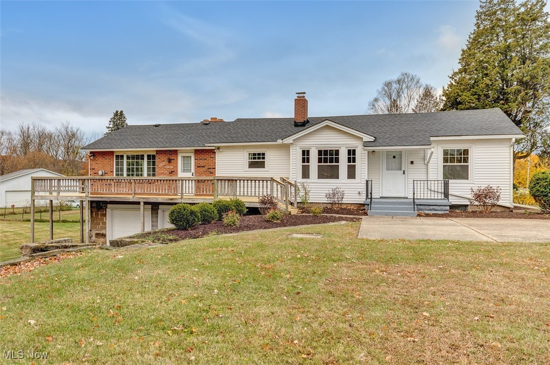 Beautiful front view of house featuring a parking pad/driveway, a yard, a new roof, and brick and vinyl siding.