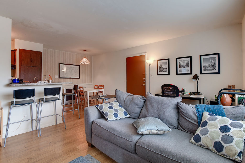 a living room with furniture and view of kitchen