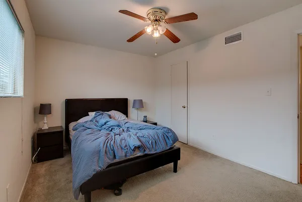 a bedroom with a bed and a ceiling fan