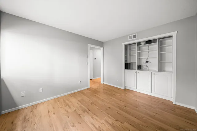an empty room with wooden floor and white walls