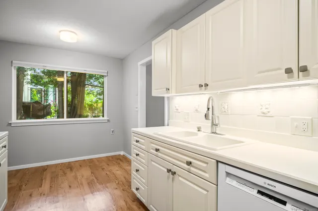 a kitchen with a sink cabinets and window
