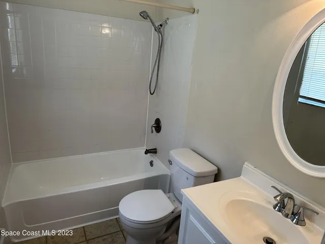 a white toilet sitting next to a bath tub