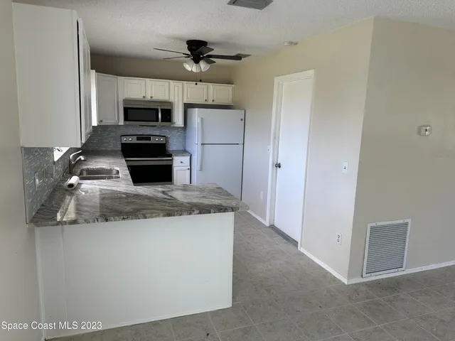 a kitchen with kitchen island white cabinets appliances and sink