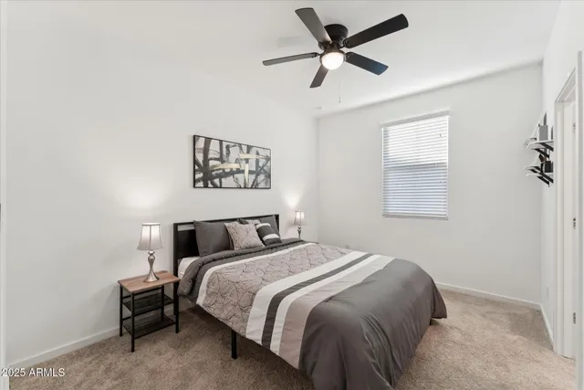 a bed room with a bed and a ceiling fan