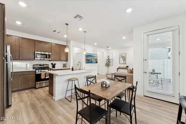 a kitchen with stainless steel appliances kitchen island granite countertop a kitchen island a stove a table and chairs