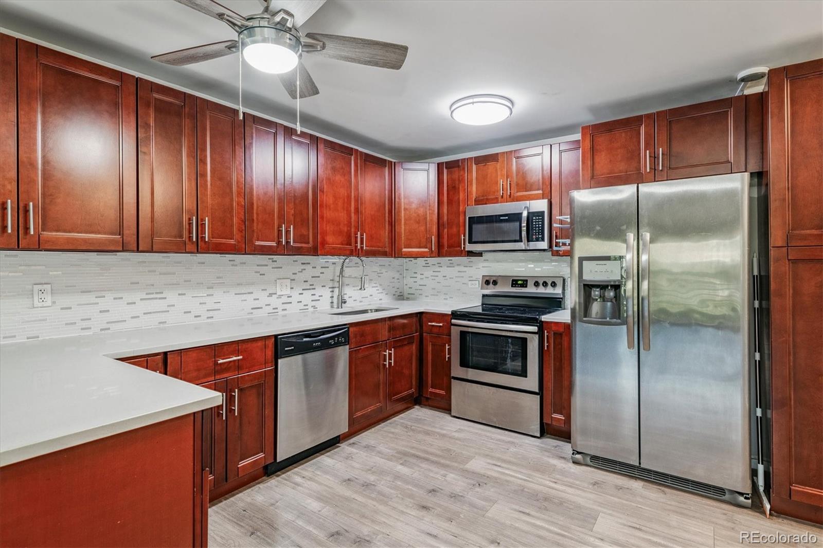 595 South Alton Way, Unit 7B Denver, CO 80247 - Photo 1 of 38 a kitchen with stainless steel appliances granite countertop a refrigerator a sink a stove with cabinets and wooden floor