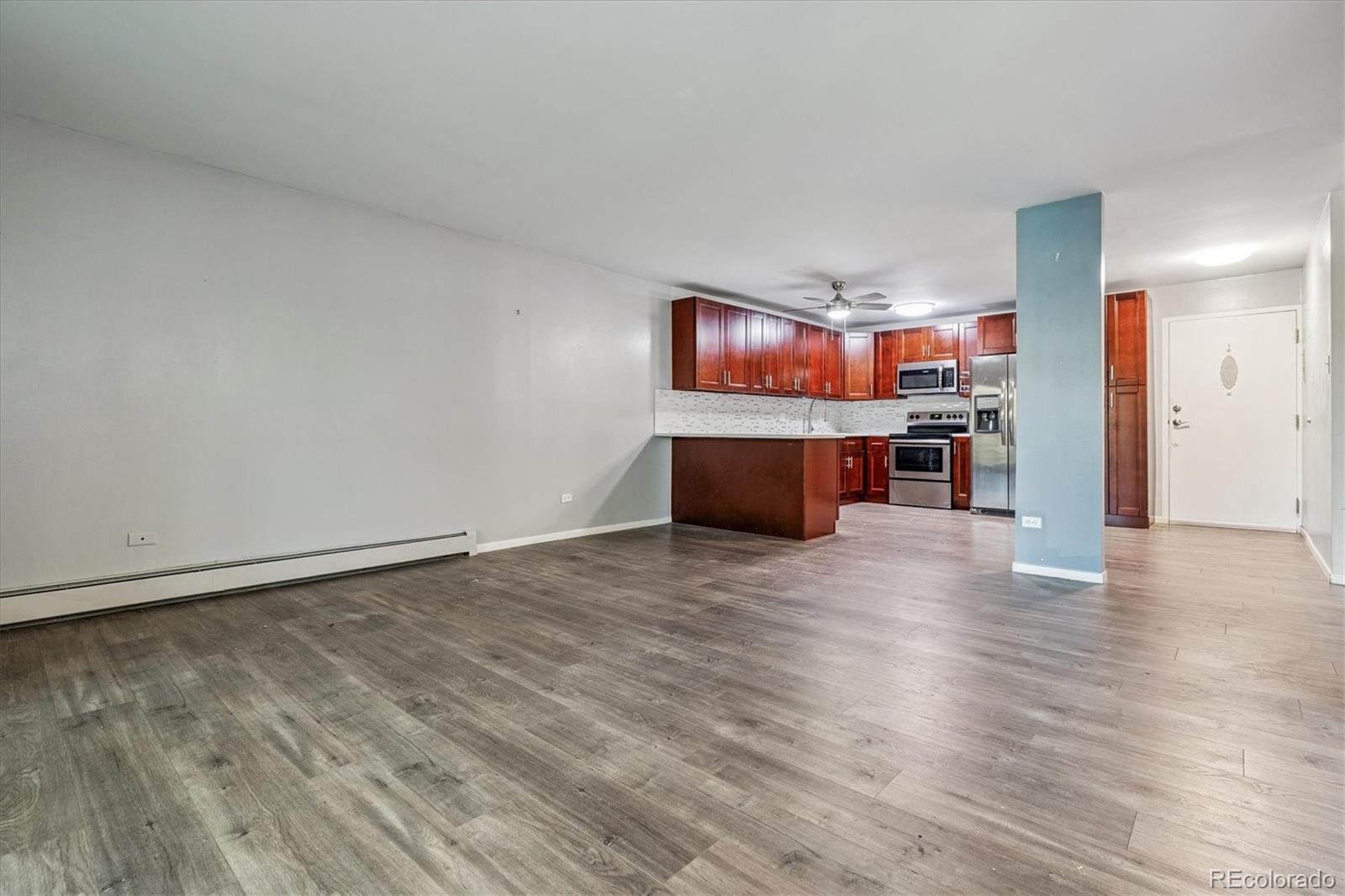 595 South Alton Way, Unit 7B Denver, CO 80247 - Photo 12 of 38 a view of kitchen and dining room with wooden floor