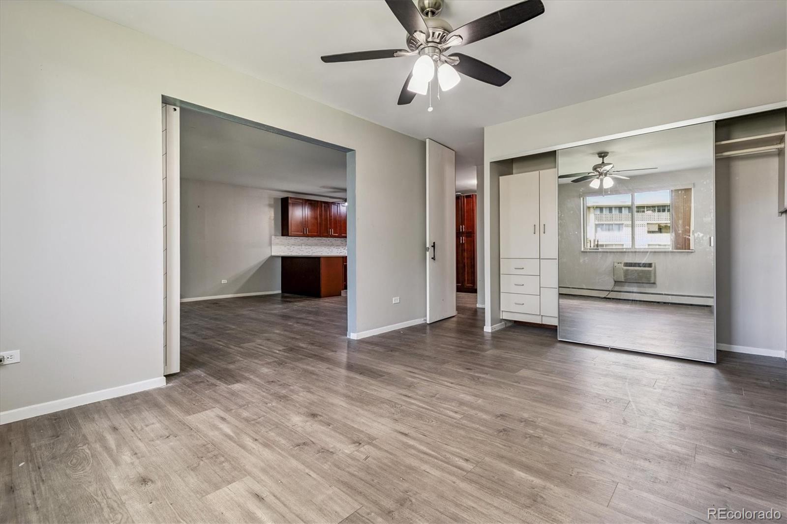 595 South Alton Way, Unit 7B Denver, CO 80247 - Photo 15 of 38 a view of a big room with wooden floor kitchen view and a window