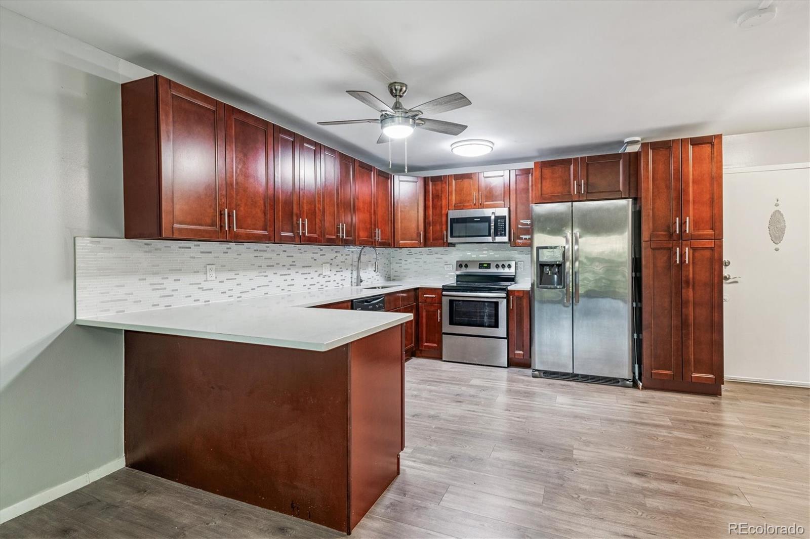 595 South Alton Way, Unit 7B Denver, CO 80247 - Photo 5 of 38 a kitchen with stainless steel appliances granite countertop a sink stove and refrigerator