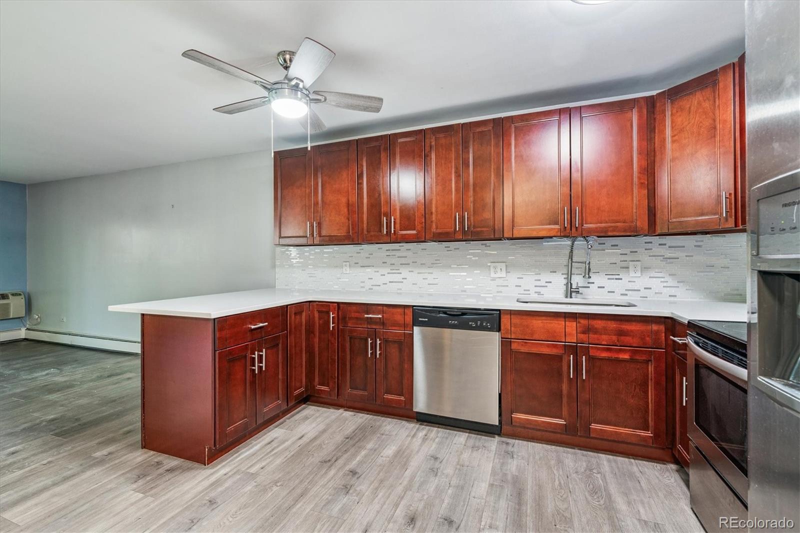 595 South Alton Way, Unit 7B Denver, CO 80247 - Photo 7 of 38 a kitchen with stainless steel appliances granite countertop wooden cabinets a sink and dishwasher