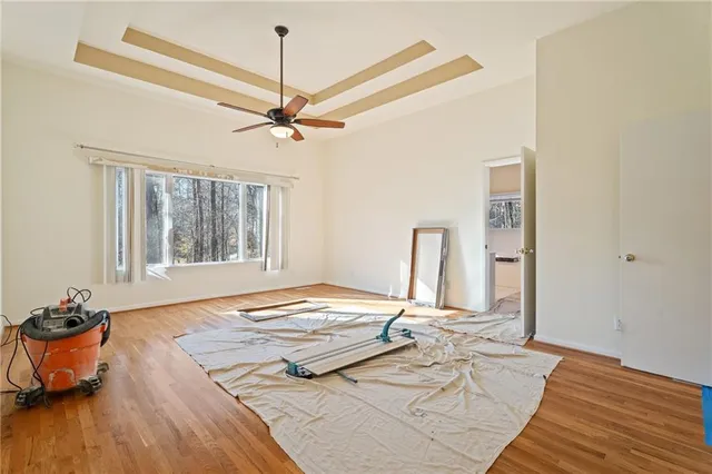 a view of a bedroom with a bed and wooden floor