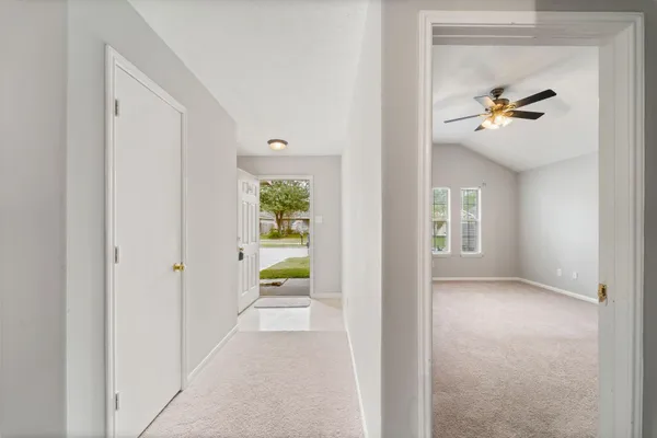 an empty room with windows and fan