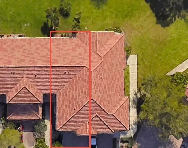 an aerial view of a house with swimming pool and large trees