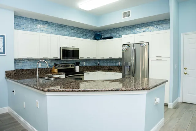 a kitchen with kitchen island granite countertop a sink and a counter top space