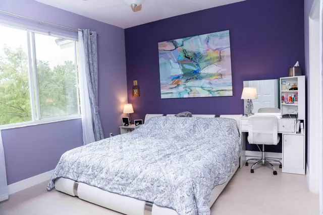a bedroom with a bed and a painting on the wall