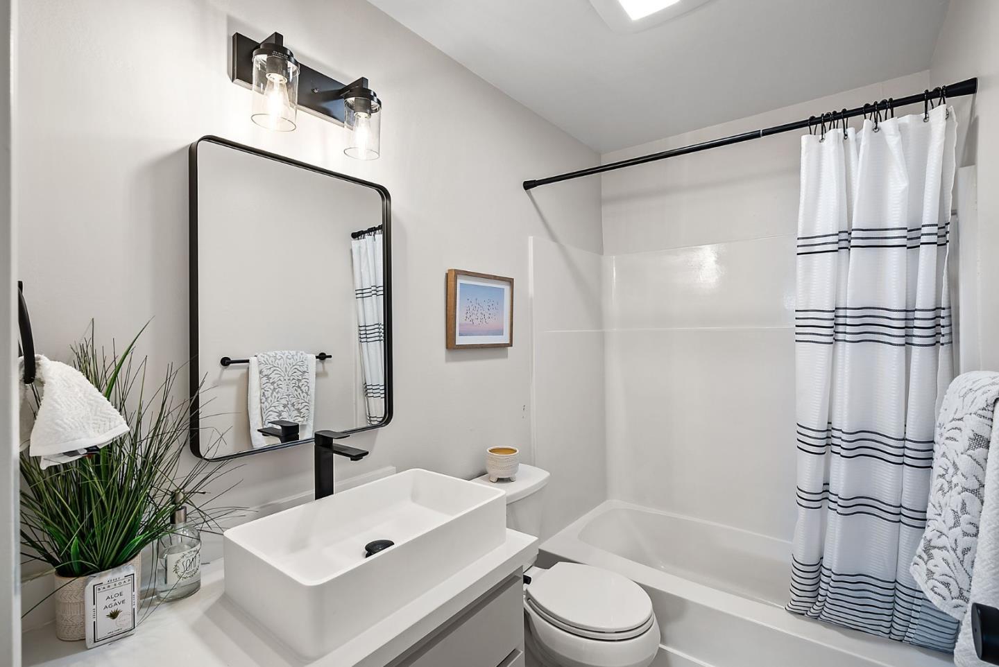 1925 46th Avenue, Unit 172 Capitola, CA 95010 - Photo 14 of 26 a bathroom with a sink toilet a mirror and shower
