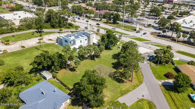 an aerial view of residential houses with outdoor space and street view