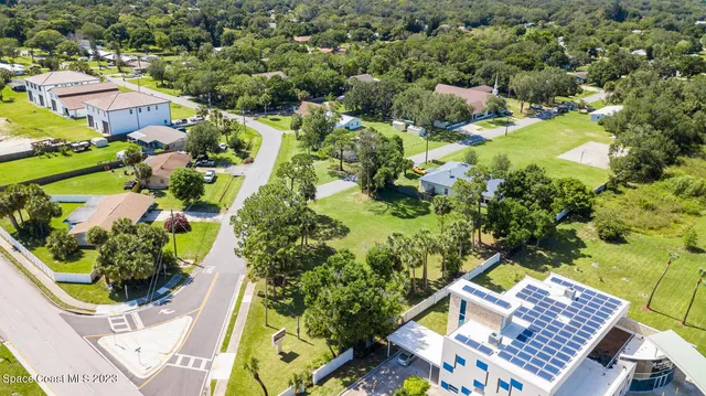 an aerial view of residential house with swimming pool and green space