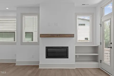 a living room with a fireplace and a window