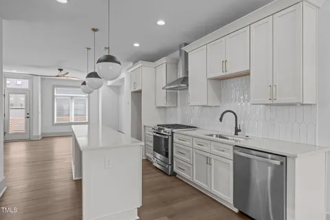 a kitchen with stainless steel appliances granite countertop a sink a stove and a refrigerator