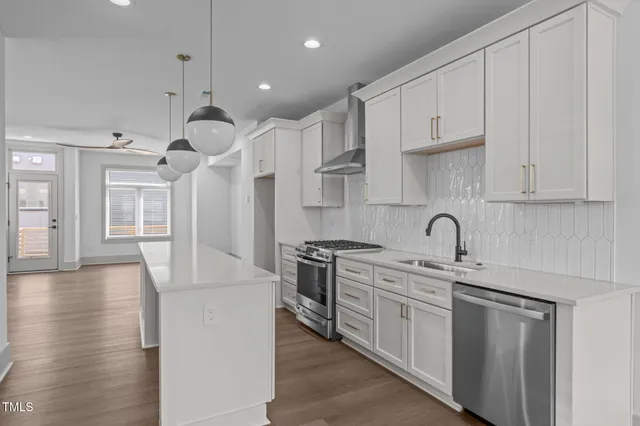 a kitchen with stainless steel appliances granite countertop a sink a stove and a refrigerator