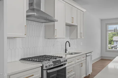 a kitchen with granite countertop a sink stove and cabinets