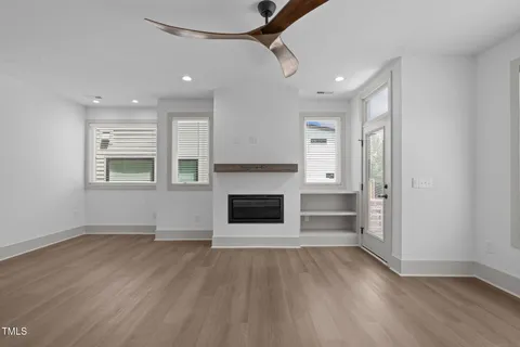 an empty room with windows and fireplace