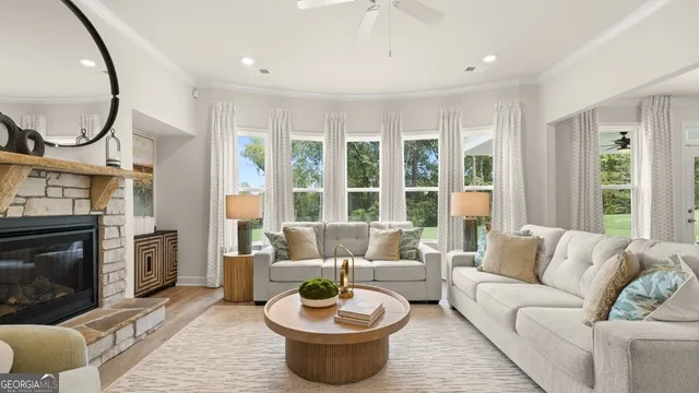 a living room with furniture a fireplace and a large window