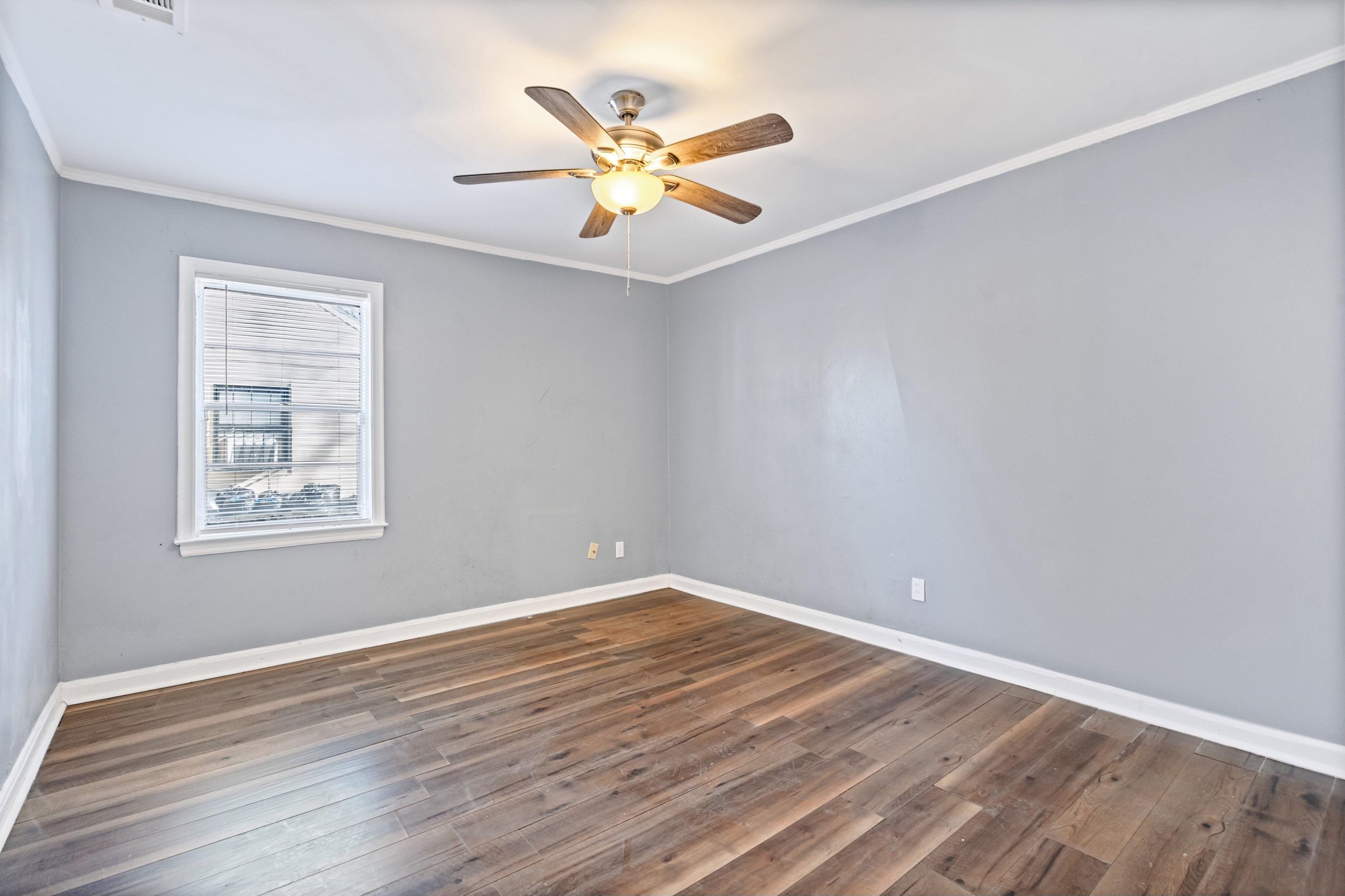 1848 Wynton Street Memphis, TN 38106 - Photo 16 of 22 Spare room with dark wood-style flooring, ornamental molding, and a ceiling fan