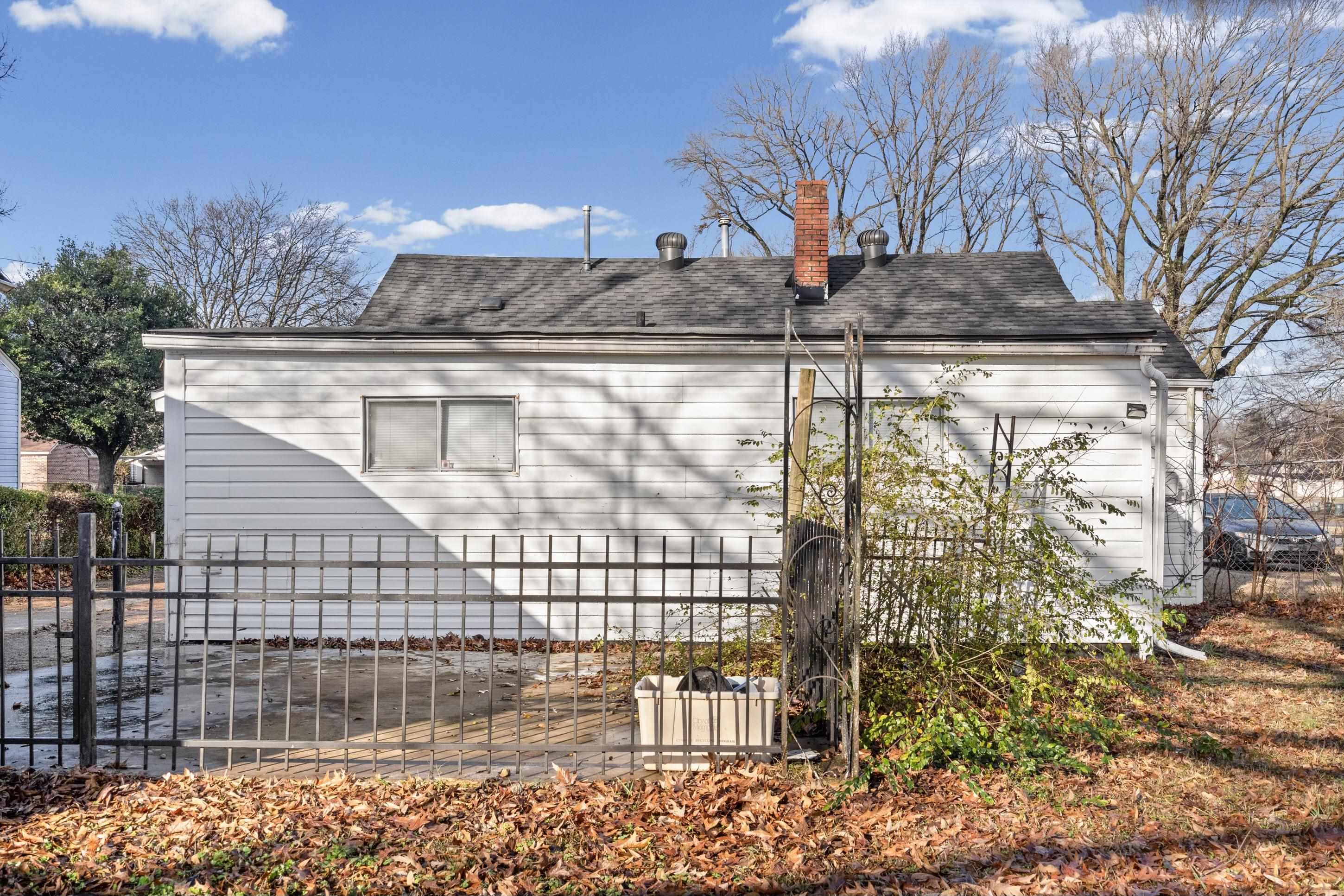 1848 Wynton Street Memphis, TN 38106 - Photo 20 of 22 View of property exterior featuring a chimney and roof with shingles