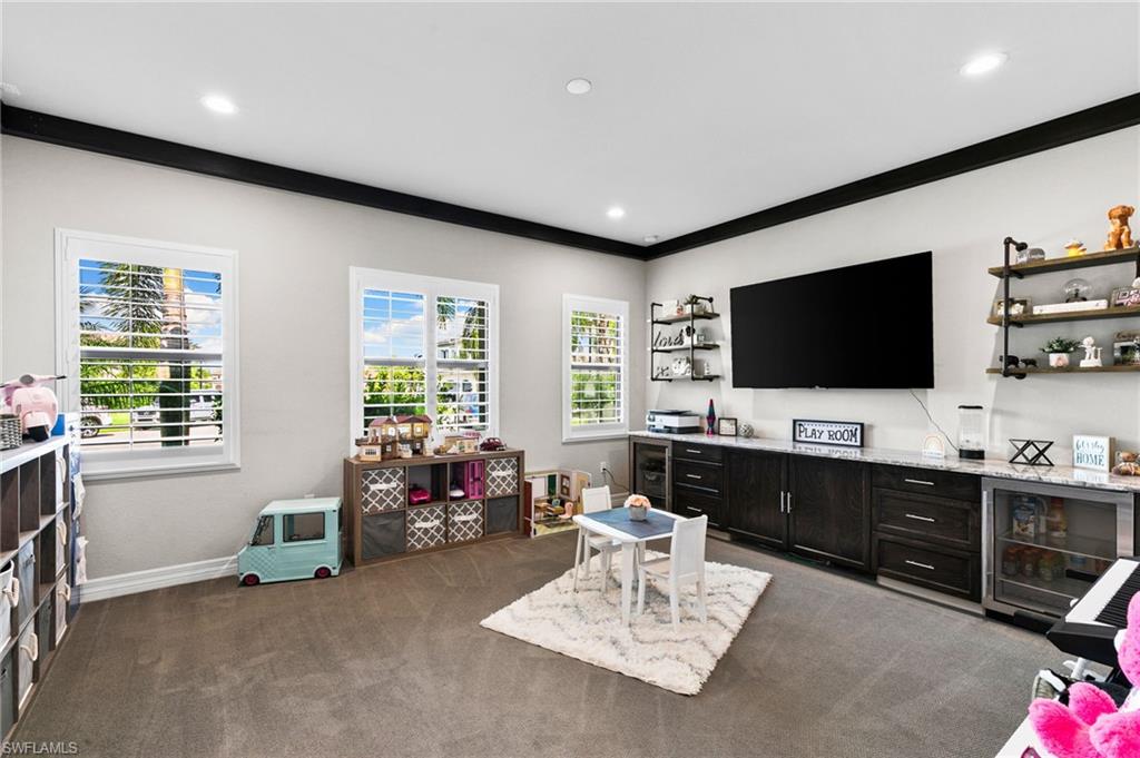 4605 Azalea Drive Naples, FL 34119 - Photo 32 of 50 a living room with furniture and a flat screen tv