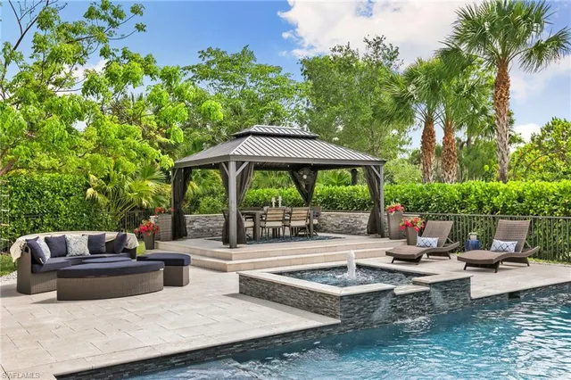 a view of swimming pool with outdoor seating and plants
