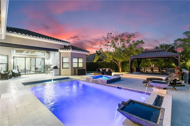 a view of a swimming pool with sitting area and furniture