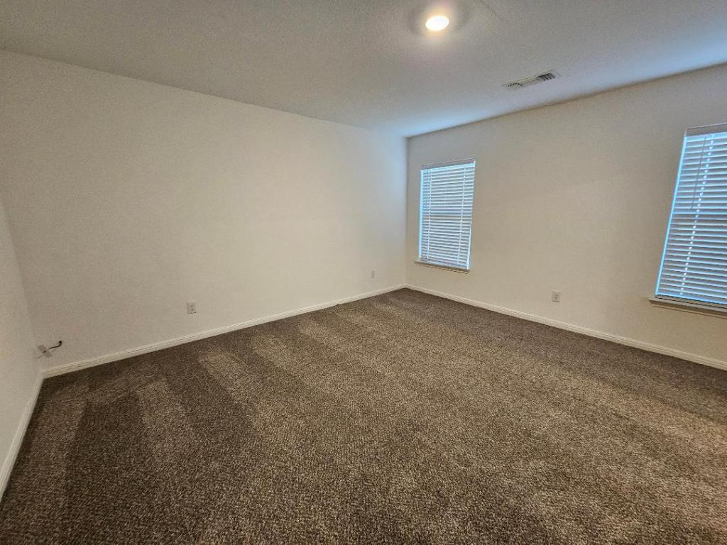 17904 Speculator Lane Elgin, TX 78621 - Photo 6 of 15 Empty room with dark carpet and a textured ceiling